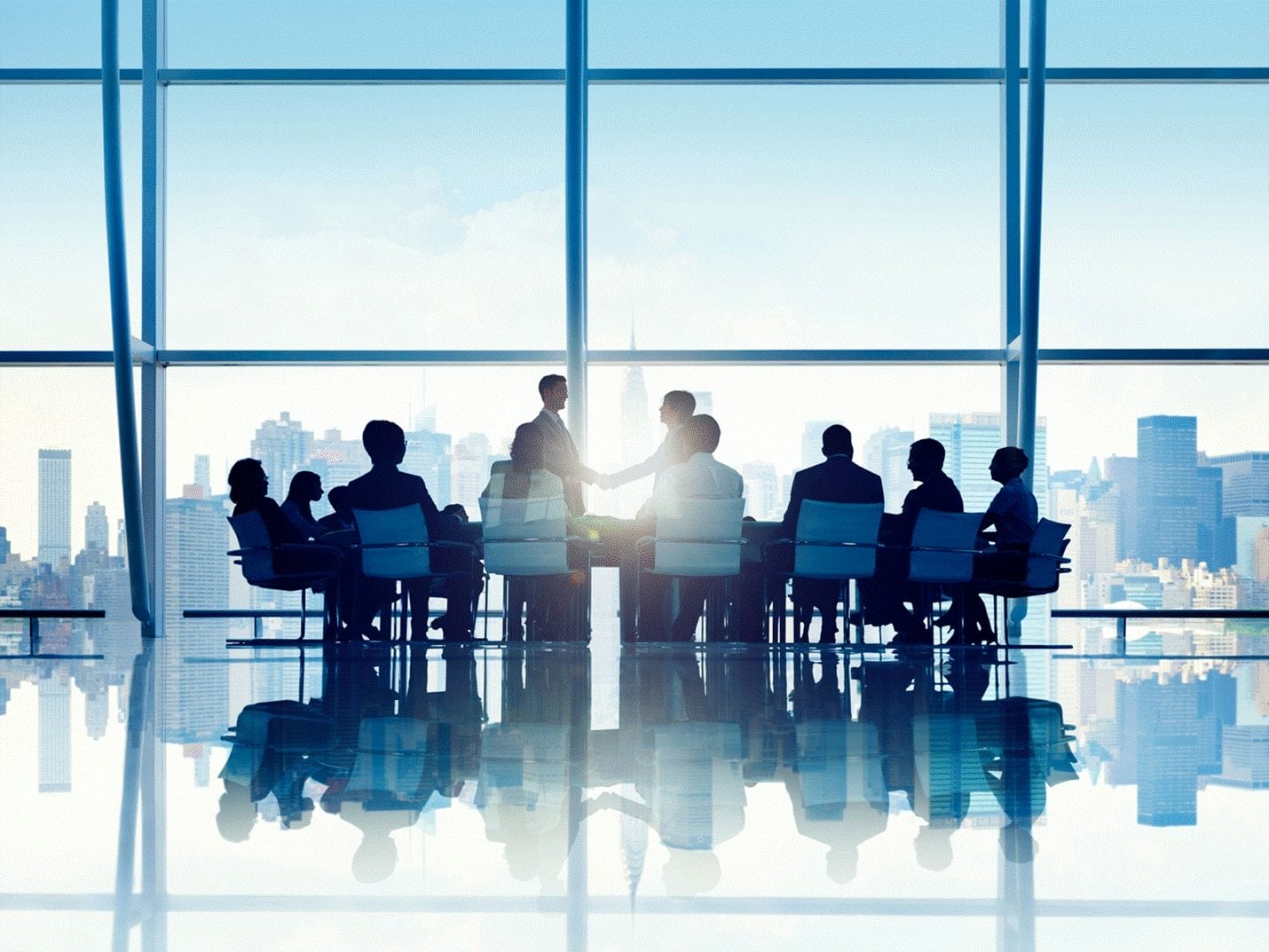 Shaking hands in boardroom.