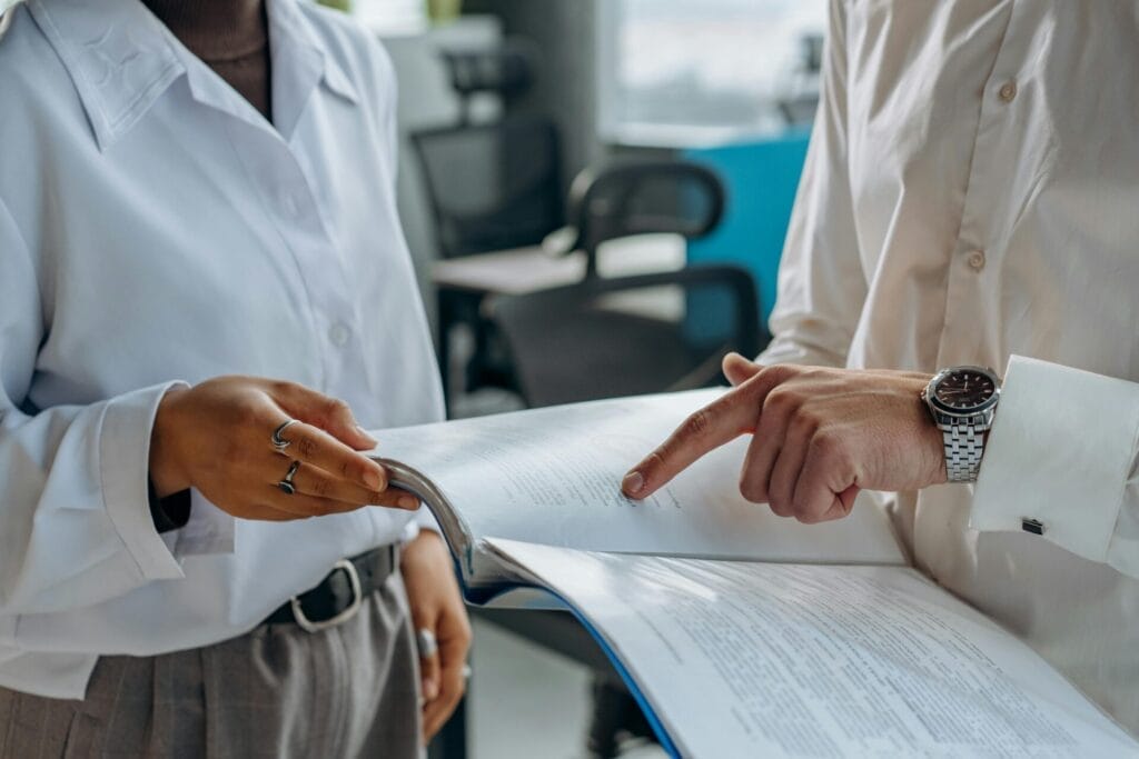 Close-up of two colleagues reviewing a document together in an office setting.