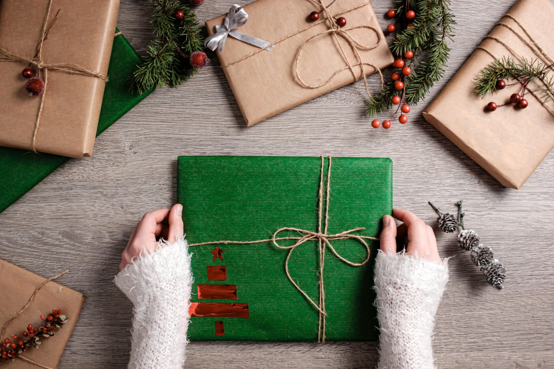 Wrapping a gift in green wrapping paper.